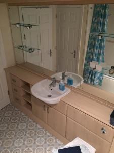 uma casa de banho com um lavatório e um espelho em Beach Break Aberavon Holiday Home by the Sea em Port Talbot