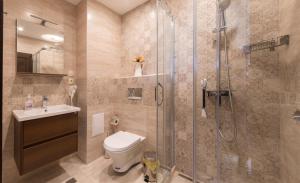 a bathroom with a shower and a toilet and a sink at City Apartments Triumph in Varna City +45 photos