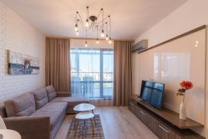 a living room with a couch and a tv at City Apartments Triumph in Varna City