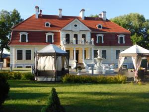 una grande casa con un gazebo di fronte di Sventes Muiža a Svente