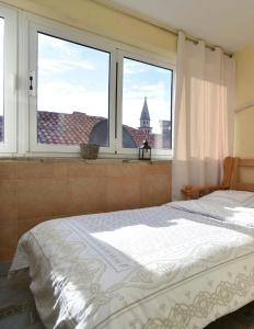 a bedroom with a bed and a large window at Comfort Inn Old Town in Budva