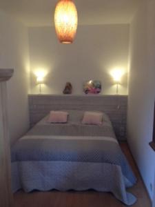 een slaapkamer met een bed met 2 kussens erop bij village vosgien in Gérardmer