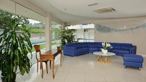 a living room with a blue couch and a table at Oceania Hotel in Kota Kinabalu