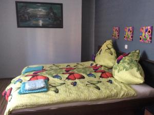Una cama con una manta amarilla con flores. en URS Ferienwohnung Wertheim, en Wertheim