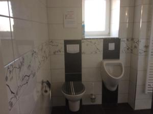 a bathroom with a toilet and a urinal and a sink at URS Ferienwohnung Wertheim in Wertheim +13 photos