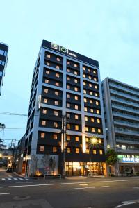 a tall building with a sign on top of it at ICI HOTEL Ueno Shin Okachimachi in Tokyo