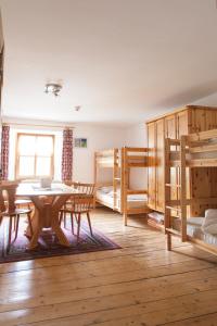 a room with a table and two bunk beds at Romedihof Backpacker Hostel in Karrösten