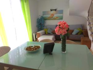 a living room with a table with a vase of flowers at Apto PLAYA LA CALA in front of the beach Free parking in Málaga