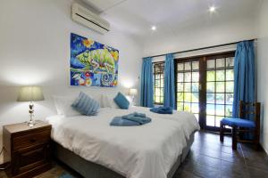 En eller flere senge i et værelse på Maputaland Guest House
