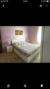una camera con letto e parete viola di Appartamento - Casa vacanza Nonna Grazia a Roma