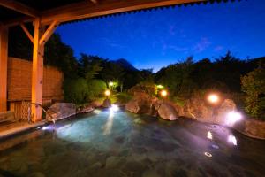 a swimming pool at night with lights at Yufuin Sansuikan in Yufu