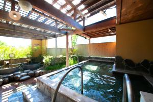 a swimming pool in a building with a hot tub at Yufuin Sansuikan in Yufuin