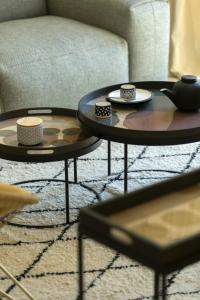 two coffee tables in a living room with a couch at Les Bastides du Mas de l'Amarine in Saint-Rémy-de-Provence