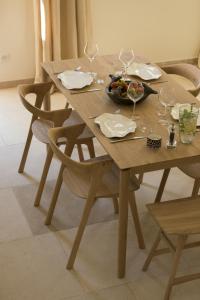 a wooden table with a bowl of food and wine glasses at Les Bastides du Mas de l'Amarine in Saint-Rémy-de-Provence