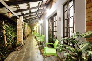 une rangée de chaises vertes dans un bâtiment avec des plantes dans l'établissement Maputaland Guest House, à St Lucia