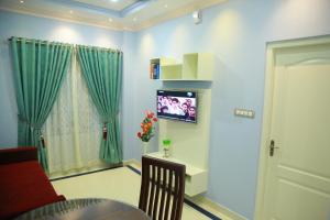 sala de estar con TV en la pared en Villino Kalipparambil en Ernakulam