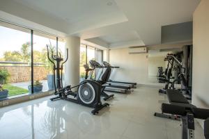 une salle de sport avec plusieurs tapis de course et machines elliptiques dans l'établissement Prominent Corporate Residency, à Gandhinagar