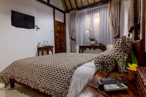 婆羅浮屠的住宿－The Omah Borobudur，卧室配有一张床,墙上配有电视。