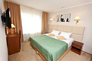 Cette chambre comprend un lit et une télévision à écran plat. dans l'établissement Gvardeiskaya Hotel, à Kazan