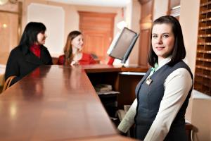 a woman standing at a desk in an office at Gvardeiskaya Hotel in Kazan