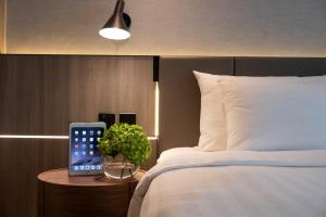 um quarto com uma cama e um tablet numa mesa em Nathan Hotel em Hong Kong