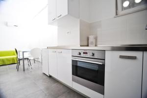 a kitchen with white cabinets and a stove at Split Mari Apartment in Split