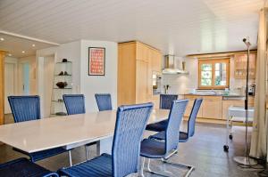 una cocina con una mesa larga y sillas azules en Apartment Atlanta - GRIWA RENT AG, en Grindelwald