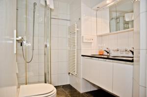 Baño blanco con aseo y lavamanos en Apartment Atlanta - GRIWA RENT AG, en Grindelwald