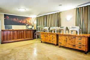 a hair salon with wooden desks and chairs in a room at Nolangeni Hotel in Kokstad +28 photos
