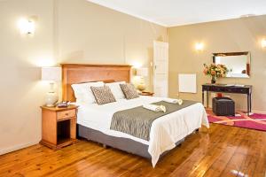 a bedroom with a bed and a table with a mirror at Nolangeni Hotel in Kokstad