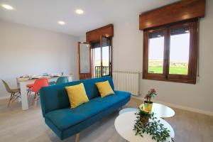 a living room with a blue couch and a table at Mirador de Cervantes in Toledo