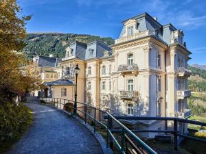 a large building on a hill next to a road at Hapimag Ferienwohnungen Bad Gastein in Bad Gastein