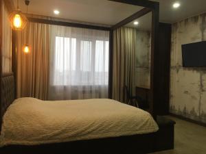 een slaapkamer met een groot bed en een raam bij LOFT - Interior design apartments in Oral