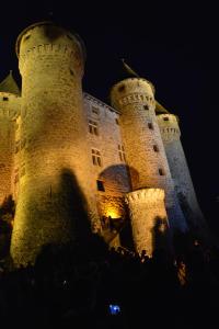 a large castle with two towers at night at Chateau De Val in Lanobre