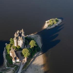 an island with a castle in the water at Chateau De Val in Lanobre