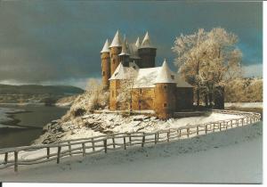 a castle in the snow next to a fence at Chateau De Val in Lanobre