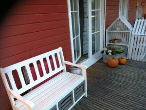 a white bench sitting on a porch with pumpkins at Wohnung im Schwedenhaus in Bad Laasphe
