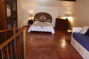 a bedroom with a bed and a dresser in a room at Le Gite du Moulin de Milan in Cheval-Blanc