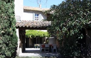 une terrasse avec une table et des chaises devant un bâtiment dans l'établissement Le Gite du Moulin de Milan, à Cheval-Blanc