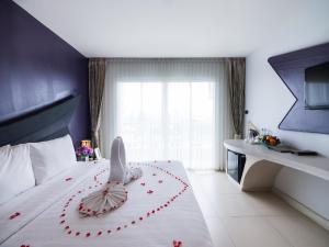 a bedroom with a bed with a flower decoration on it at Blue Boat Design Hotel in North Pattaya