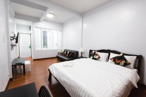 ein Schlafzimmer mit einem großen weißen Bett in einem Zimmer in der Unterkunft House of Happiness in Bangkok