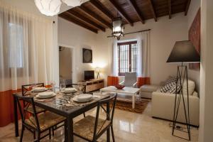 een woonkamer met een tafel en stoelen en een bank bij Apartamento De Lujo En Antiguo Convento in Granada