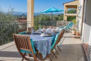 a table with chairs and an umbrella on a patio at La Muse du Paradis in Montauroux