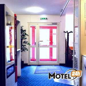 a hallway with a glass door and a door that is open at Motel 24h Hannover in Hannover