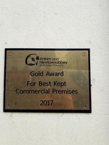 een bord op een muur met gouden prijzen voor best onderhouden commerciële gebouwen bij Laverty's - The Black Bull Inn in Randalstown