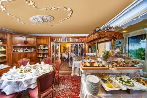 une salle à manger avec une table et des assiettes de nourriture dans l'établissement Hotel Irmchen, à Maintal