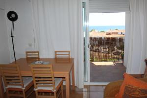 sala de estar con mesa y sillas y balcón en Estudi vista mar La Fosca, en Palamós