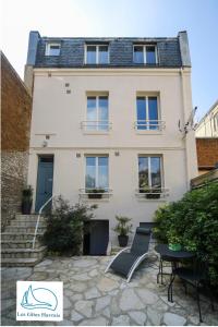 a white house with a table and chairs in front of it at Les Gîtes Havrais in Le Havre