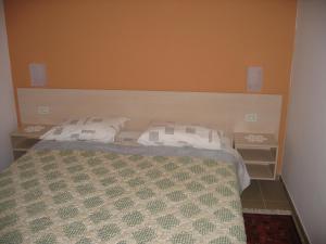 1 dormitorio con 1 cama con 2 almohadas blancas en Apartments Mediteraneo, en Tar