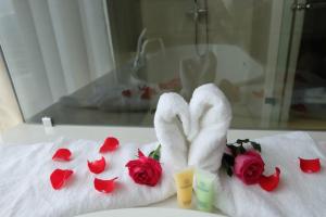 a pair of towels and roses on a bed at Indochine Hotel in Kon Tum (2) +42 photos